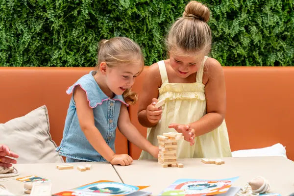 Duas meninas a jogar com os blocos de madeira do kit Rabiskas